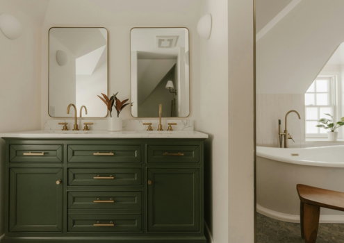 A modern bathroom vanity with two sinks and mirrors.
